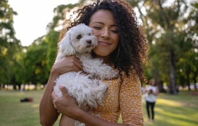 بانوی جوان در آغوش گرفتن یک سگ سفید کوچک